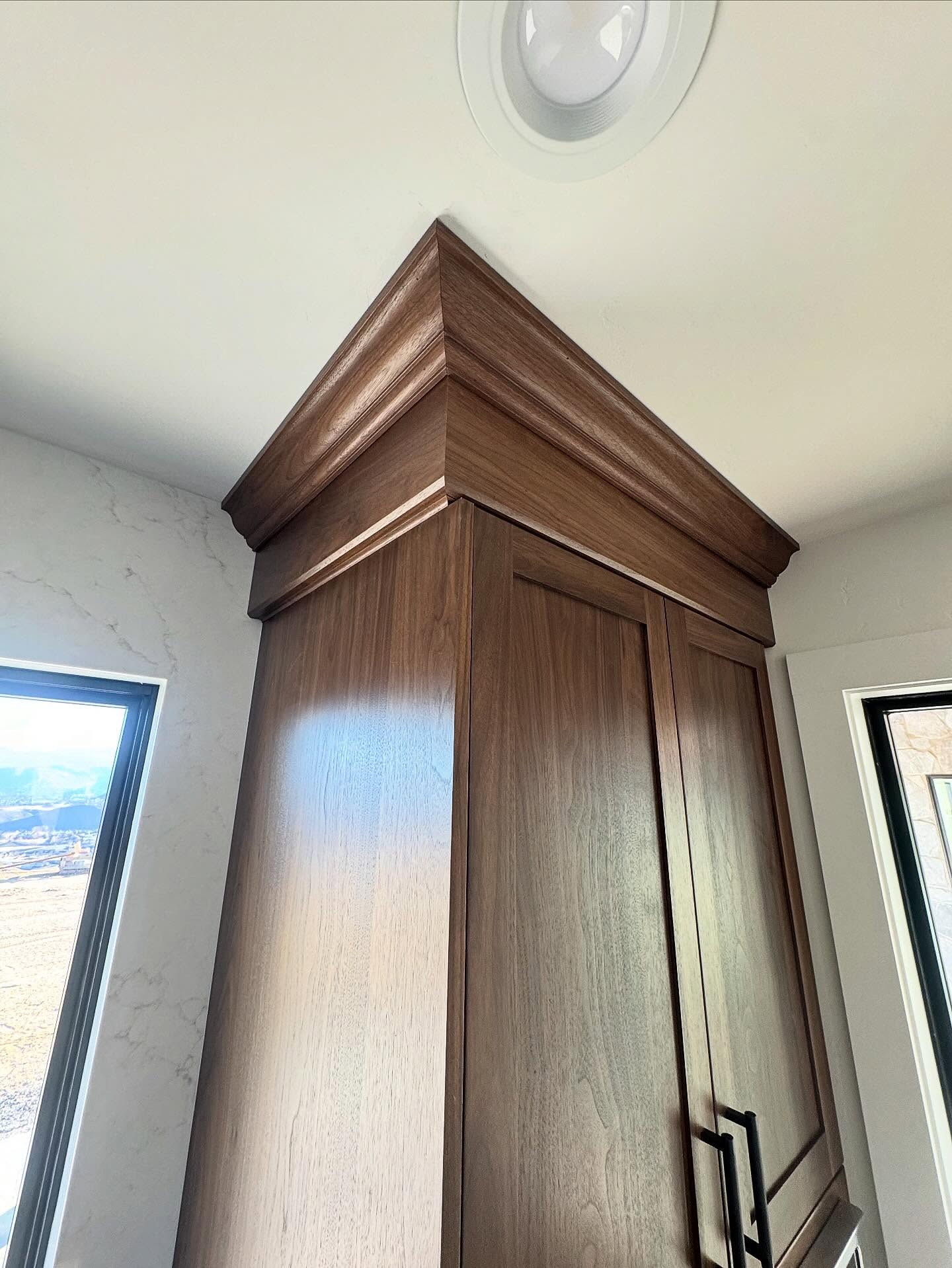 Crown moulding fitted above natural-wood cabinetry.