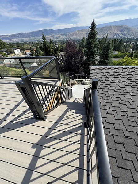 Pale decking, glass panels and black metal stair railings around the same outdoor space, view 7.