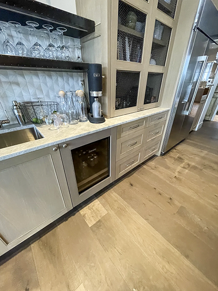 Beverage cabinet with mesh-front doors, glassware storage and an under-counter wine refrigerator.