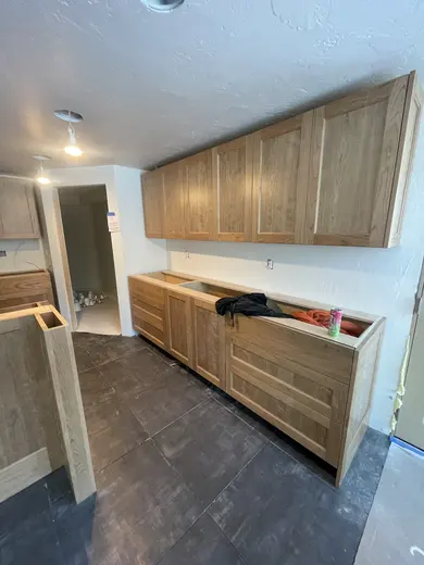 Wood railings with black balusters around a loft and the kitchen visible below, view 2.
