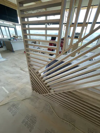 Intersecting wood slats beside the staircase, with wider installation views, view 5.