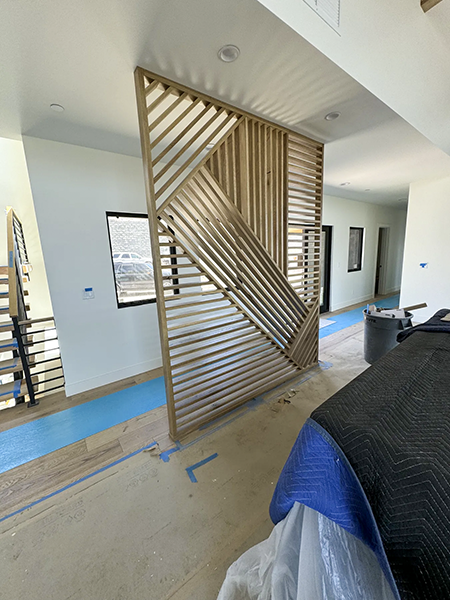 Intersecting wood slats beside the staircase, with wider installation views, view 8.