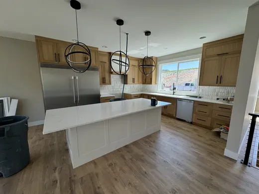 Natural wood cabinetry and a white island progressing through installation, view 3.