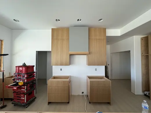 Slab wood cabinets, a gray island and a recessed wood-trimmed niche, view 1.