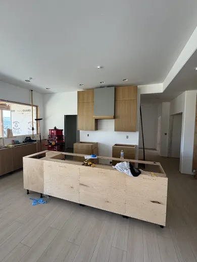 Slab wood cabinets, a gray island and a recessed wood-trimmed niche, view 2.