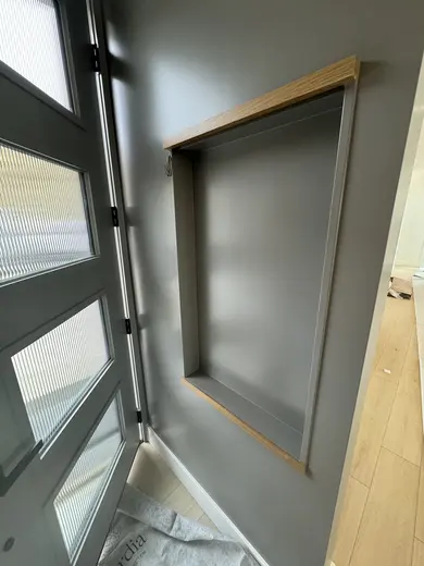 Slab wood cabinets, a gray island and a recessed wood-trimmed niche, view 14.