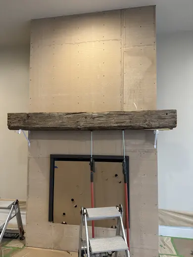 Wood mantel installation followed by the stone fireplace surround, view 1.