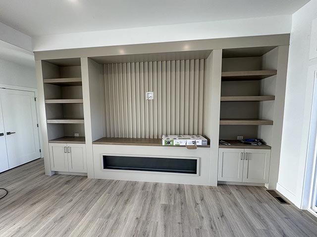 Fluted fireplace wall with side cabinets and shelves at successive installation stages, view 7.